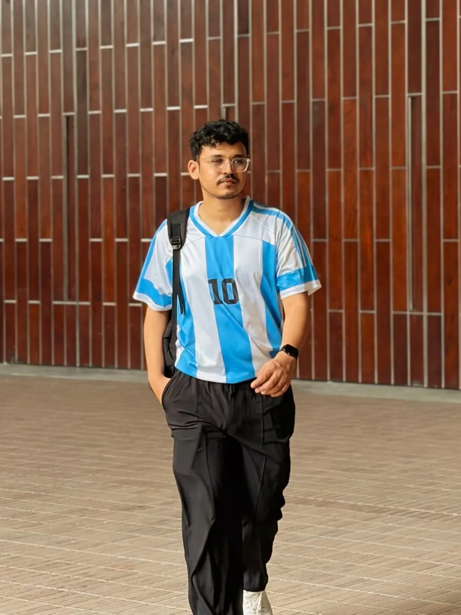 Mahdi Hasan walking in front of a tiled building