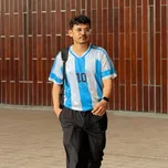 Mahdi Hasan, outdoors in front of a glass-fronted building